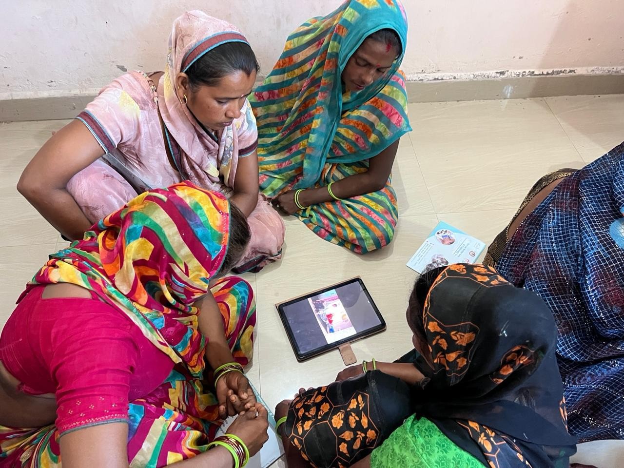 A Digital Sakhi runs a session from a tablet in a village courtyard