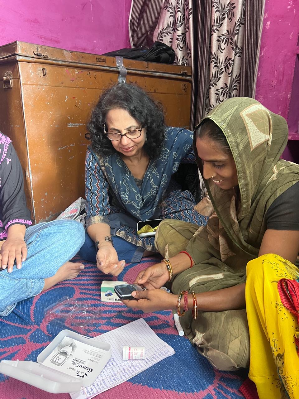 Komal Khanna seated with a Jagan Foundation frontline health worker during a home health visit in rural Rajasthan